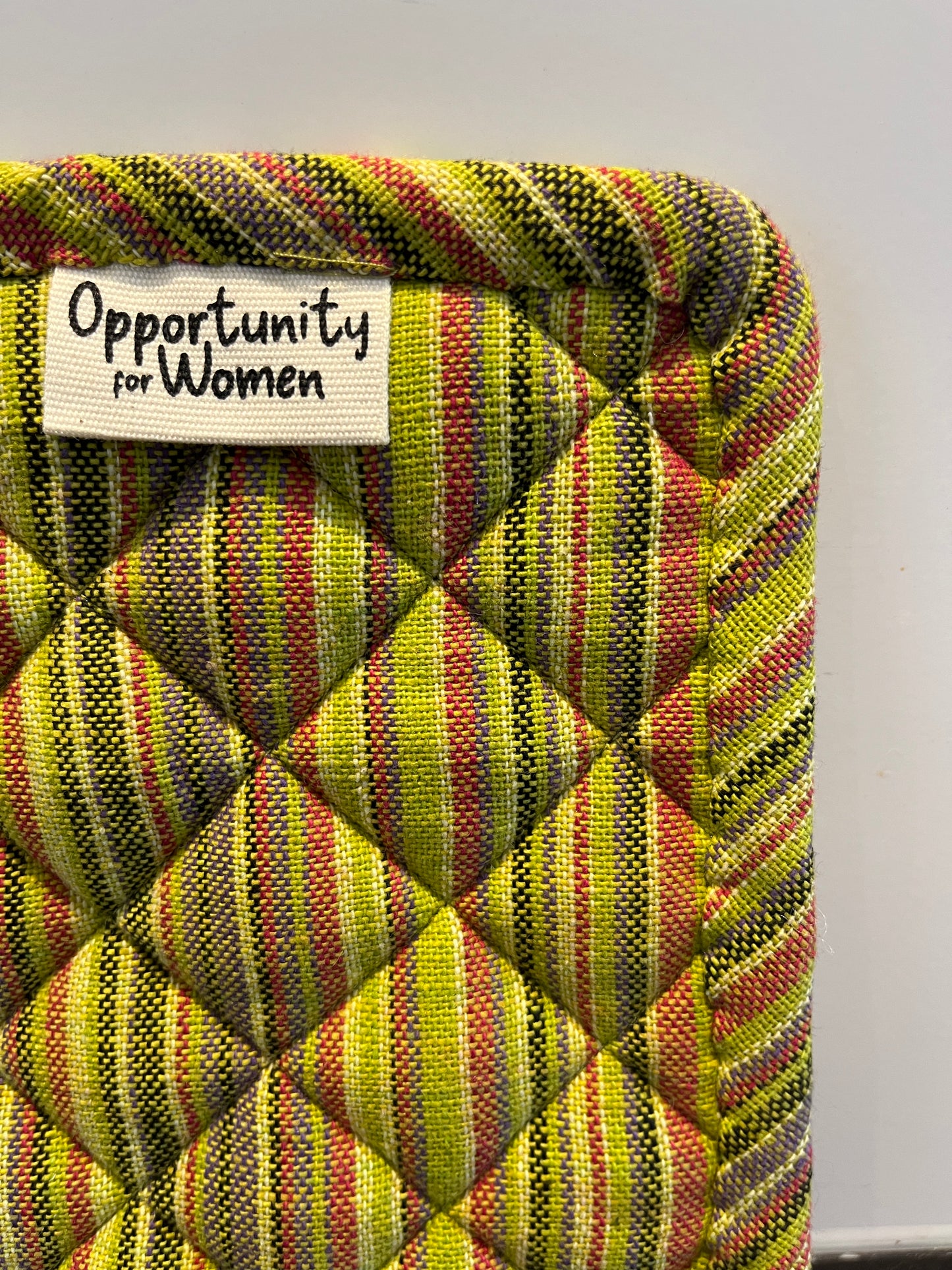 Grüner quadratischer Topflappen mit bunten Linien