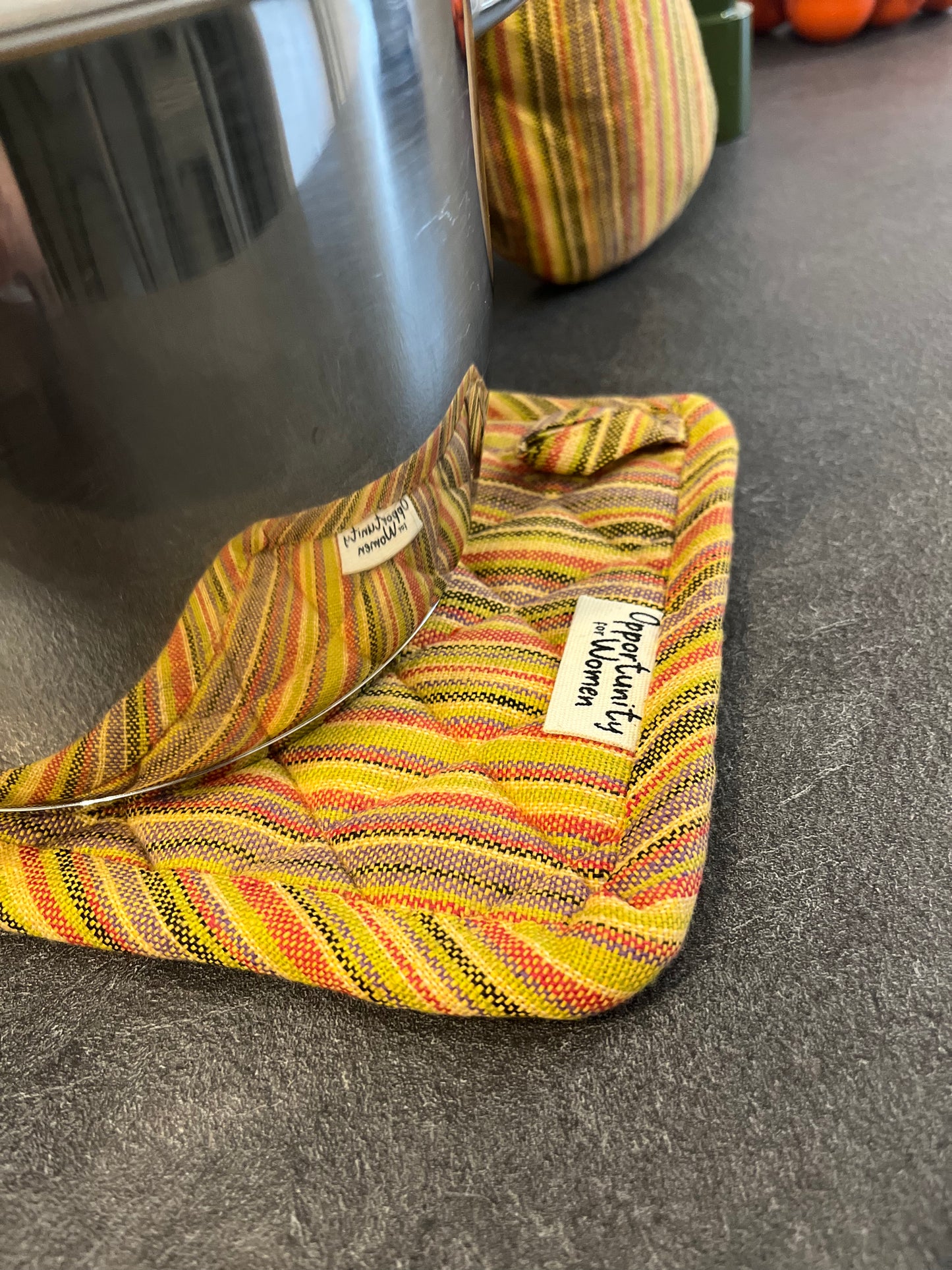 Gelber quadratischer Topflappen mit bunten Linien