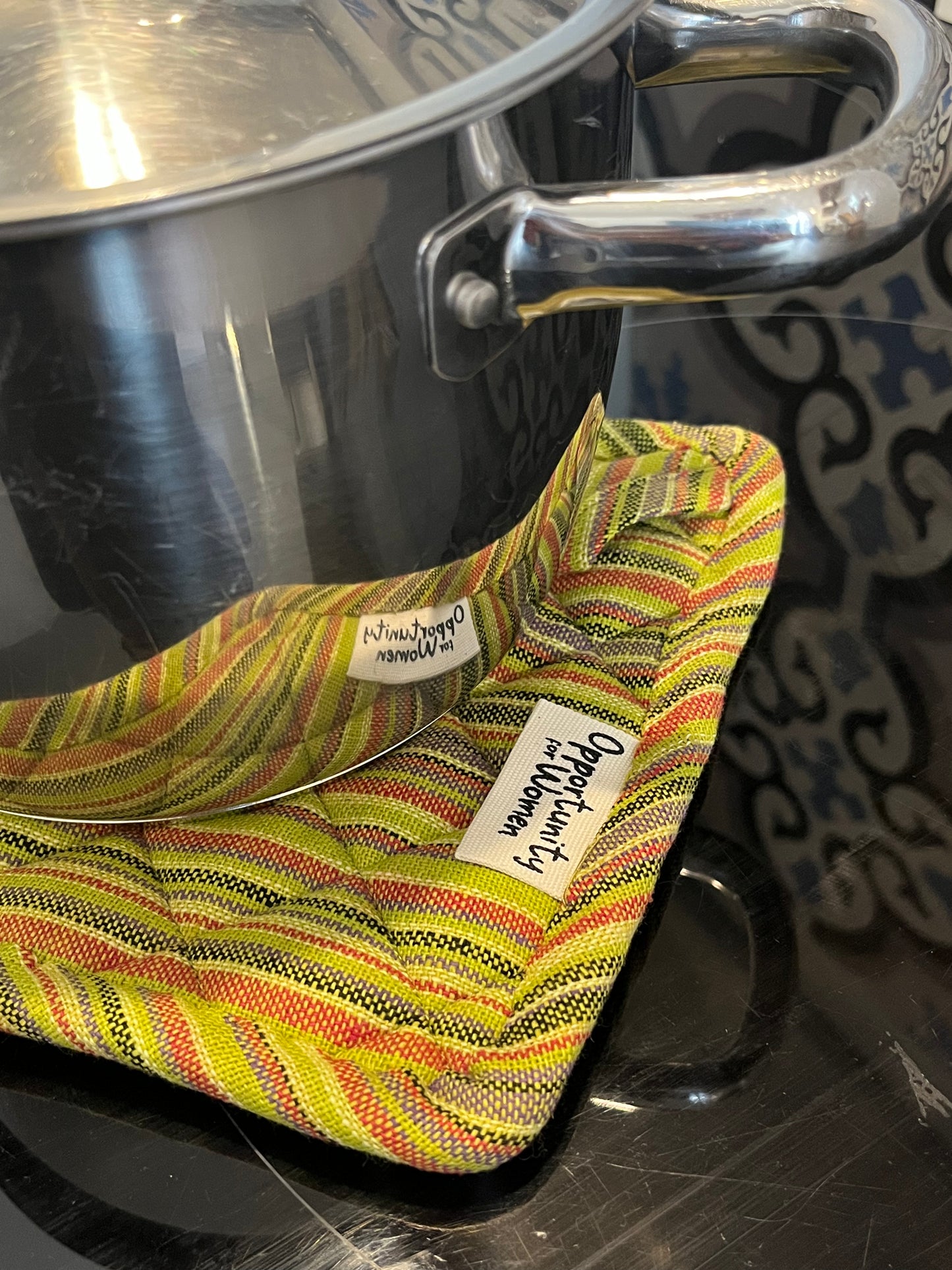 Grüner quadratischer Topflappen mit bunten Linien