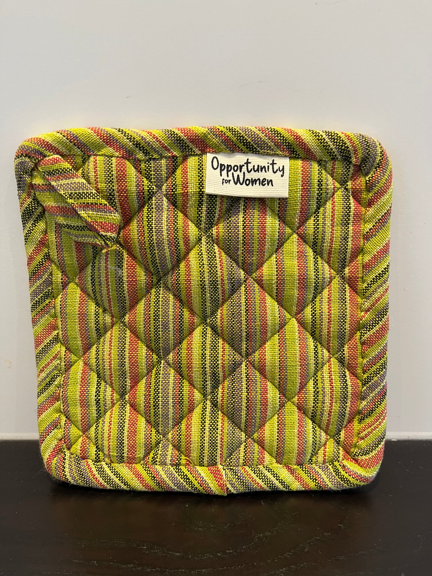 Grüner quadratischer Topflappen mit bunten Linien